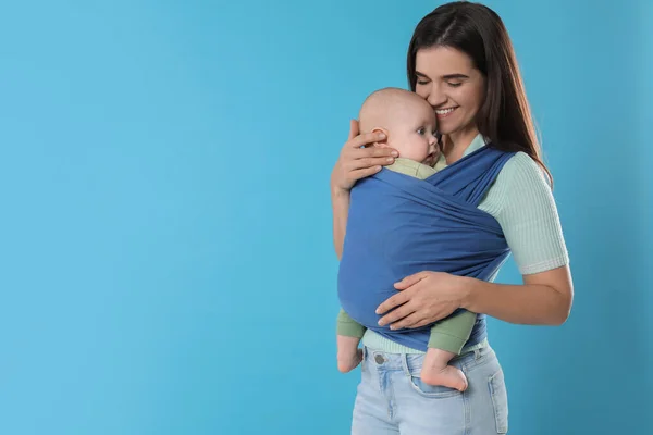 Moeder Houdt Haar Kind Draagdoek Babydrager Lichtblauwe Achtergrond Ruimte Voor — Stockfoto