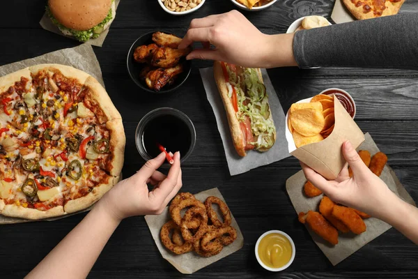 Vrienden Eten Pizza Kippenvleugels Ander Fastfood Aan Zwarte Houten Tafel — Stockfoto