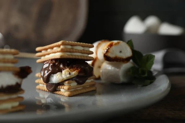 stock image Delicious marshmallow sandwiches with crackers and chocolate on grey plate, closeup