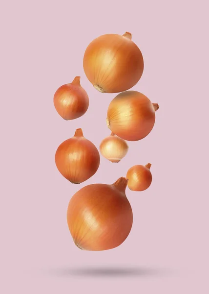Many Onion Bulbs Falling Pastel Pink Background — Stock Photo, Image