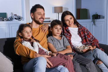 Akşamları evde televizyon izleyen bir aile.