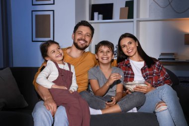 Mutlu aile akşamları evde televizyon seyrediyor.