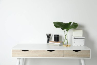 Duvarın yanında beyaz masası olan rahat bir iş yeri. Metin için boşluk