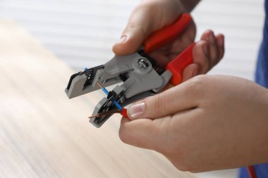 Bulanık arka planda profesyonel elektrikçi kablosu sökme, yakın plan