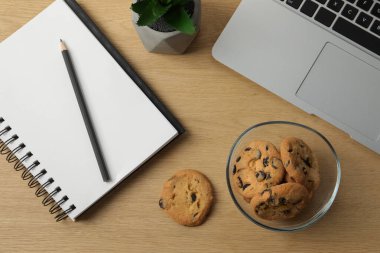 Çikolata parçalı kurabiyeler, dizüstü bilgisayar, iş yerindeki ahşap masa, düz uzanma.