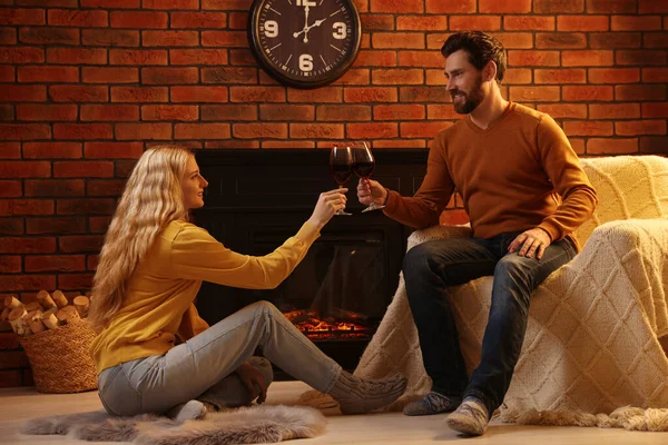 可爱的情侣们 带着酒杯在家里壁炉边共度时光 — 图库照片