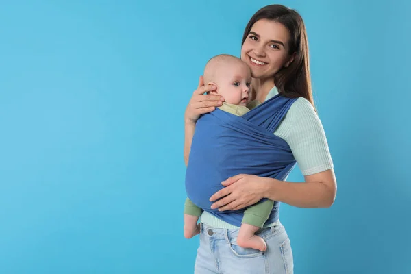 Mãe Segurando Seu Filho Funda Carrinho Bebê Fundo Azul Claro — Fotografia de Stock