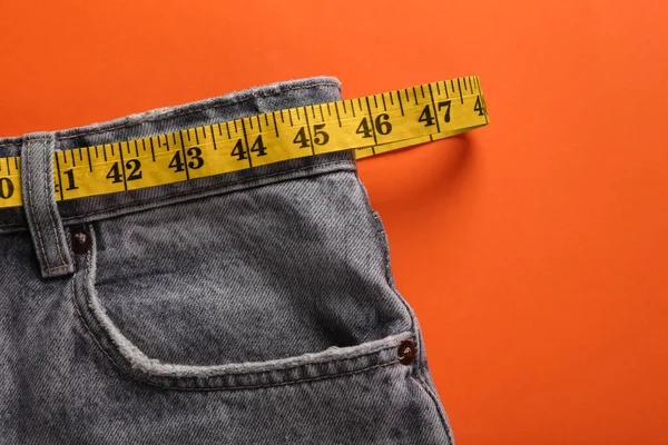 Jeans Measuring Tape Orange Background Top View Space Text Weight — Foto de Stock