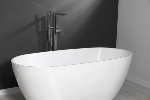 浴室の灰色の壁に近いスタイリッシュなセラミック浴槽 — ストック写真