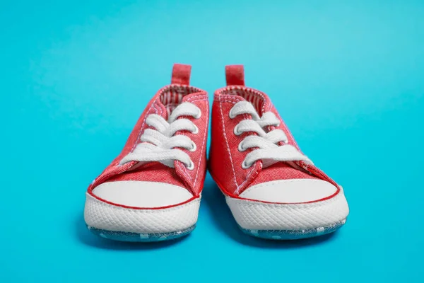 ライトブルーの背景にかわいい赤ちゃんの靴のペア — ストック写真