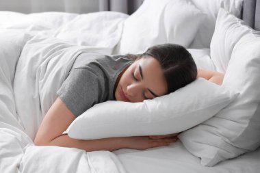 Evdeki yumuşak yatakta uyuyan güzel bir genç kadın.