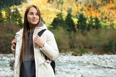 Woman with backpack in beautiful mountains. Space for text