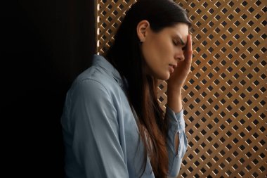 Günah çıkarma sırasında rahibi dinleyen üzgün bir kadın.