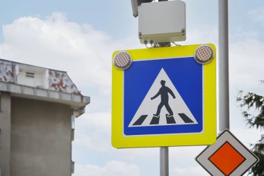 Dışarıdaki gökyüzüne karşı yaya geçidi ve ana yol işaretleri.