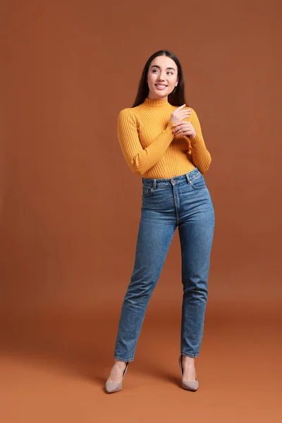Giovane Donna Jeans Alla Moda Sfondo Marrone — Foto Stock