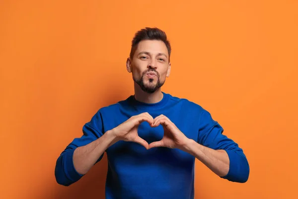 Handsome Man Making Heart Hands Blowing Kiss Orange Background — Stock Photo, Image