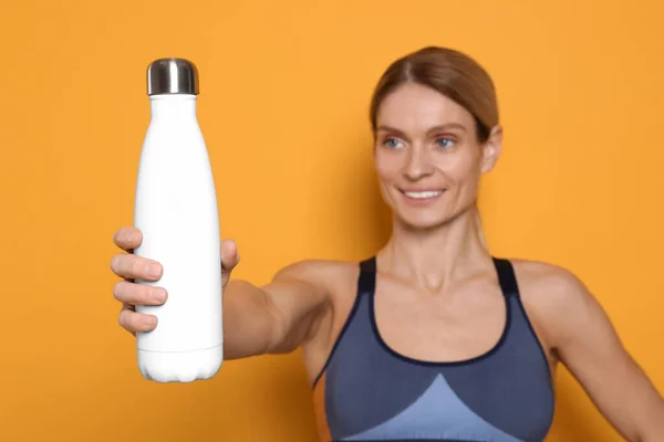 Sportlerin Mit Thermoflasche Auf Gelbem Hintergrund — Stockfoto