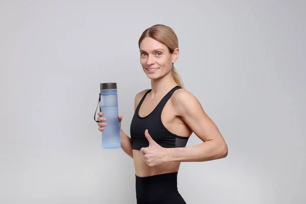 Sportvrouw Met Fles Water Lichtgrijze Achtergrond — Stockfoto