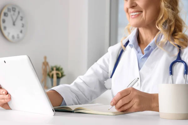 Läkare Med Tablett Och Anteckningsbok Vid Skrivbordet Kliniken Närbild Onlinemedicinskt — Stockfoto