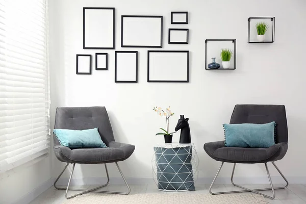 Elegante Interior Habitación Con Marcos Vacíos Colgando Pared Blanca Muebles —  Fotos de Stock