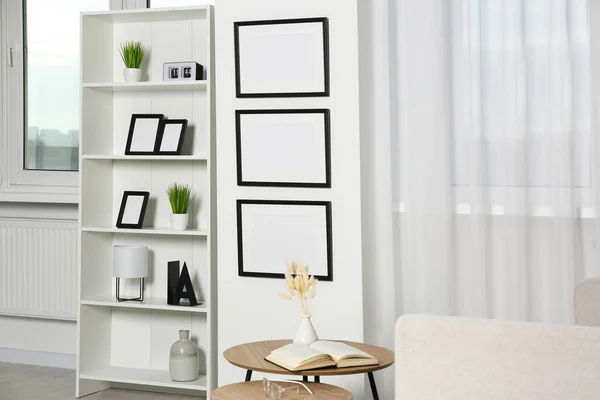 Elegante Interior Habitación Con Marcos Vacíos Colgando Pared Blanca Cerca —  Fotos de Stock