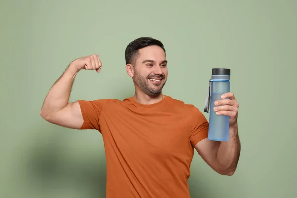 Hombre Feliz Sosteniendo Botella Transparente Agua Mostrando Brazo Sobre Fondo —  Fotos de Stock
