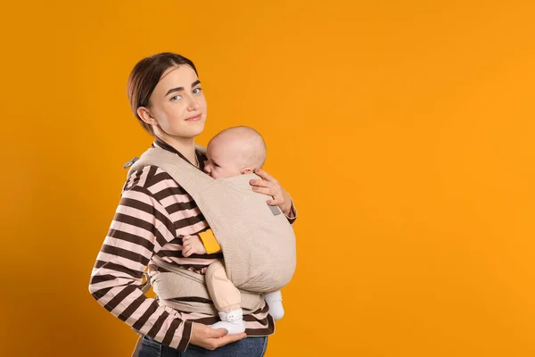 Madre Che Tiene Bambino Fionda Marsupio Sfondo Arancione Spazio Testo — Foto Stock