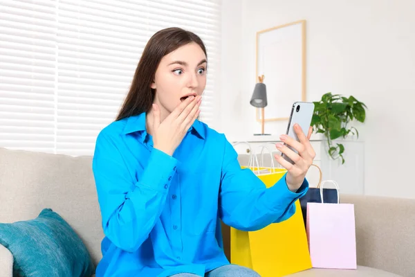 Sonderaktion Emotionale Junge Frau Schaut Auf Smartphone Auf Sofa Drinnen — Stockfoto
