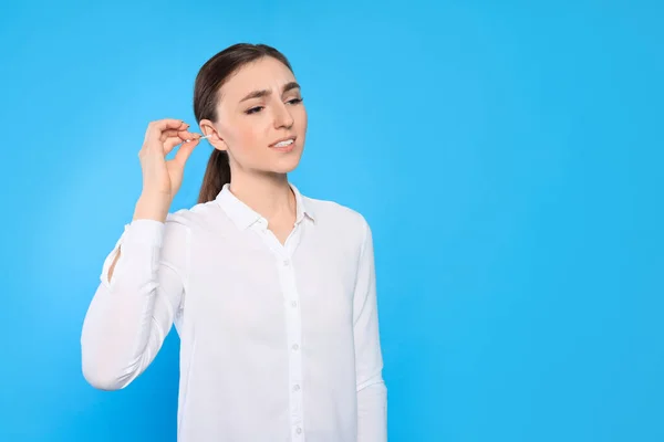 Young Woman Cleaning Ear Cotton Swab Light Blue Background Space — Foto de Stock
