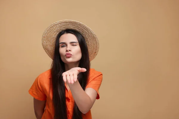 Beautiful Young Woman Straw Hat Blowing Kiss Beige Background Space — Zdjęcie stockowe