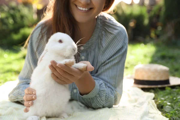 緑の芝生の上でかわいいウサギと幸せな女性屋外で クローズアップ — ストック写真
