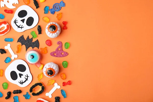 Leckere Bonbons Und Halloween Dekorationen Auf Orangefarbenem Hintergrund Flach Gelegt — Stockfoto