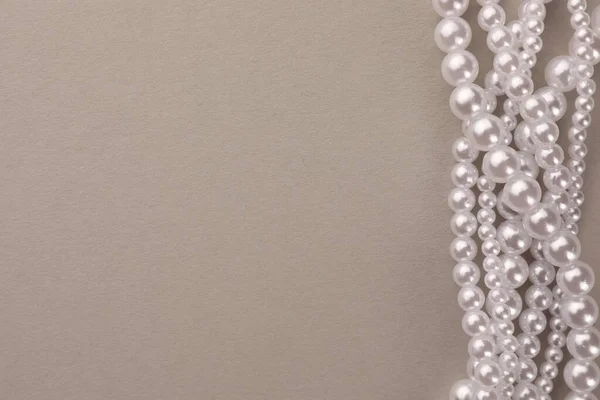 米色背景的精致珍珠项链 顶视图 案文的篇幅 — 图库照片