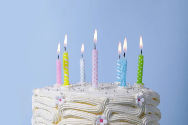 Läcker Tårta Med Grädde Och Brinnande Ljus Ljusblå Bakgrund Närbild — Stockfoto
