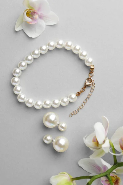 Elegantes Pendientes Perlas Brazalete Flores Orquídea Sobre Fondo Blanco Planas —  Fotos de Stock