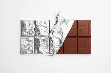 Tasty chocolate bar on white background, top view