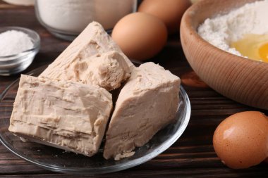 Sıkıştırılmış maya, yumurta, tuz ve un ahşap masada, yakın plan.