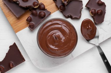 Lezzetli macun, kaşık ve çikolata parçalarıyla dolu bir kase beyaz ahşap masa, düz uzanma