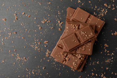 Gri masadaki lezzetli çikolata parçaları, üst manzara. Metin için boşluk