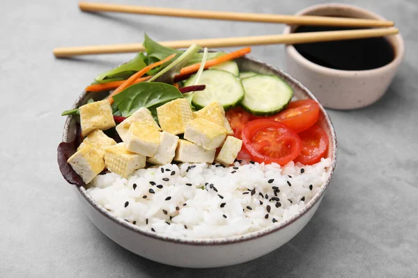 stock image Delicious poke bowl with vegetables, tofu and mesclun served on light grey table, closeup