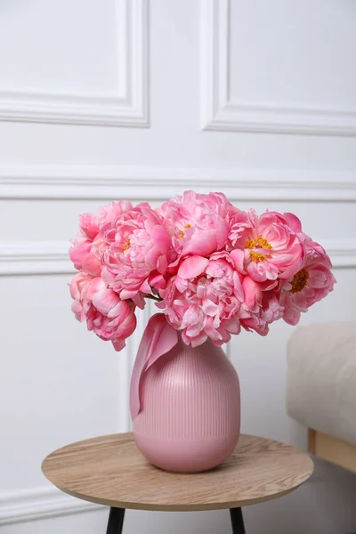 stock image Beautiful bouquet of pink peonies in vase on wooden table indoors