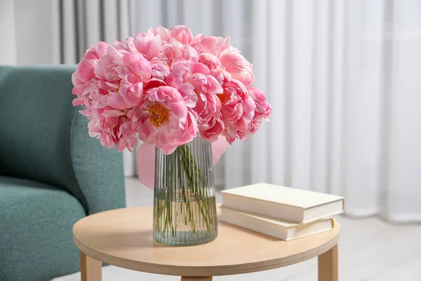 花瓶にピンクの牡丹の美しい花束や木製のテーブルの上の本室内 — ストック写真
