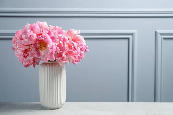 グレーの壁の近くのテーブルの上の花瓶のピンクの牡丹の美しい花束 テキストのスペース — ストック写真