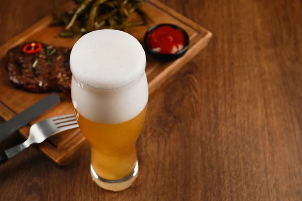 Glas Bier Heerlijke Gebakken Biefstuk Saus Houten Tafel Ruimte Voor — Stockfoto