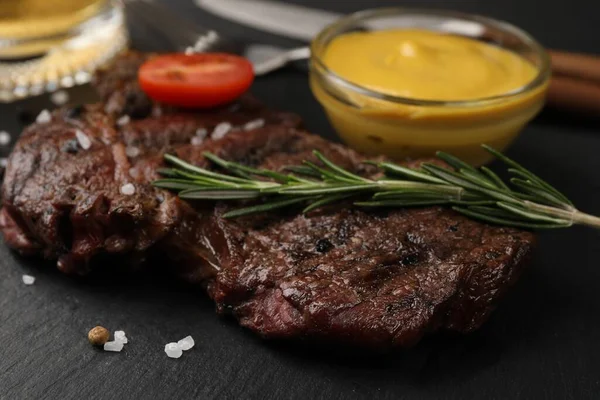 Köstliches Gebratenes Steak Mit Rosmarin Und Soße Auf Schwarzem Tisch — Stockfoto