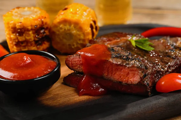 Heerlijke Gebakken Steak Met Saus Gegrilde Maïs Houten Tafel Close — Stockfoto