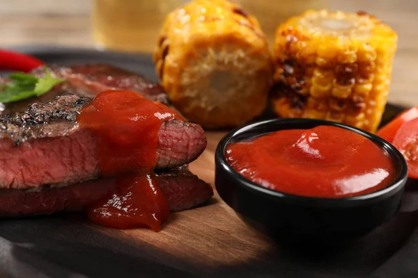 Heerlijke Gebakken Steak Met Saus Gegrilde Maïs Houten Tafel Close — Stockfoto