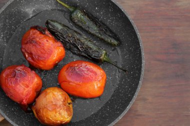 Ahşap masada salsa sosu için malzemeli kızartma tavası.