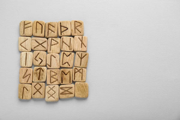 Wooden runes on white background, top view. Space for text