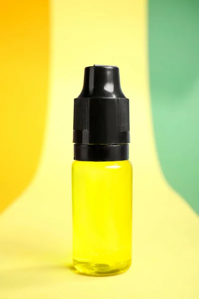 Bottle with yellow food coloring on bright background